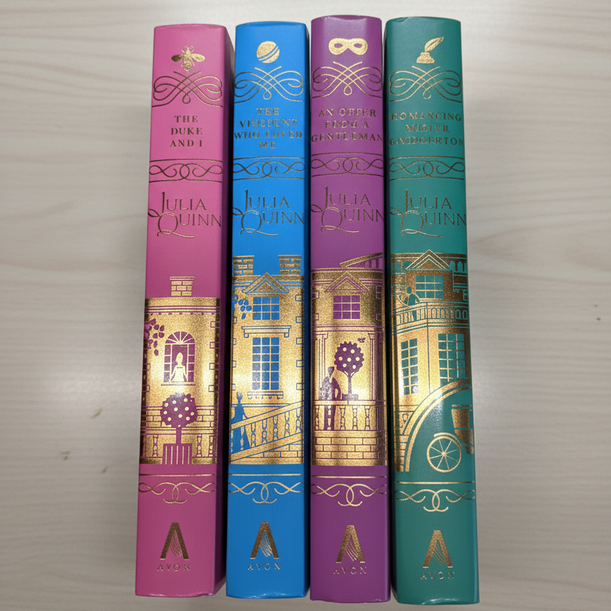 Four Bridgerton books with colorful and decorative covers on a light wooden surface.